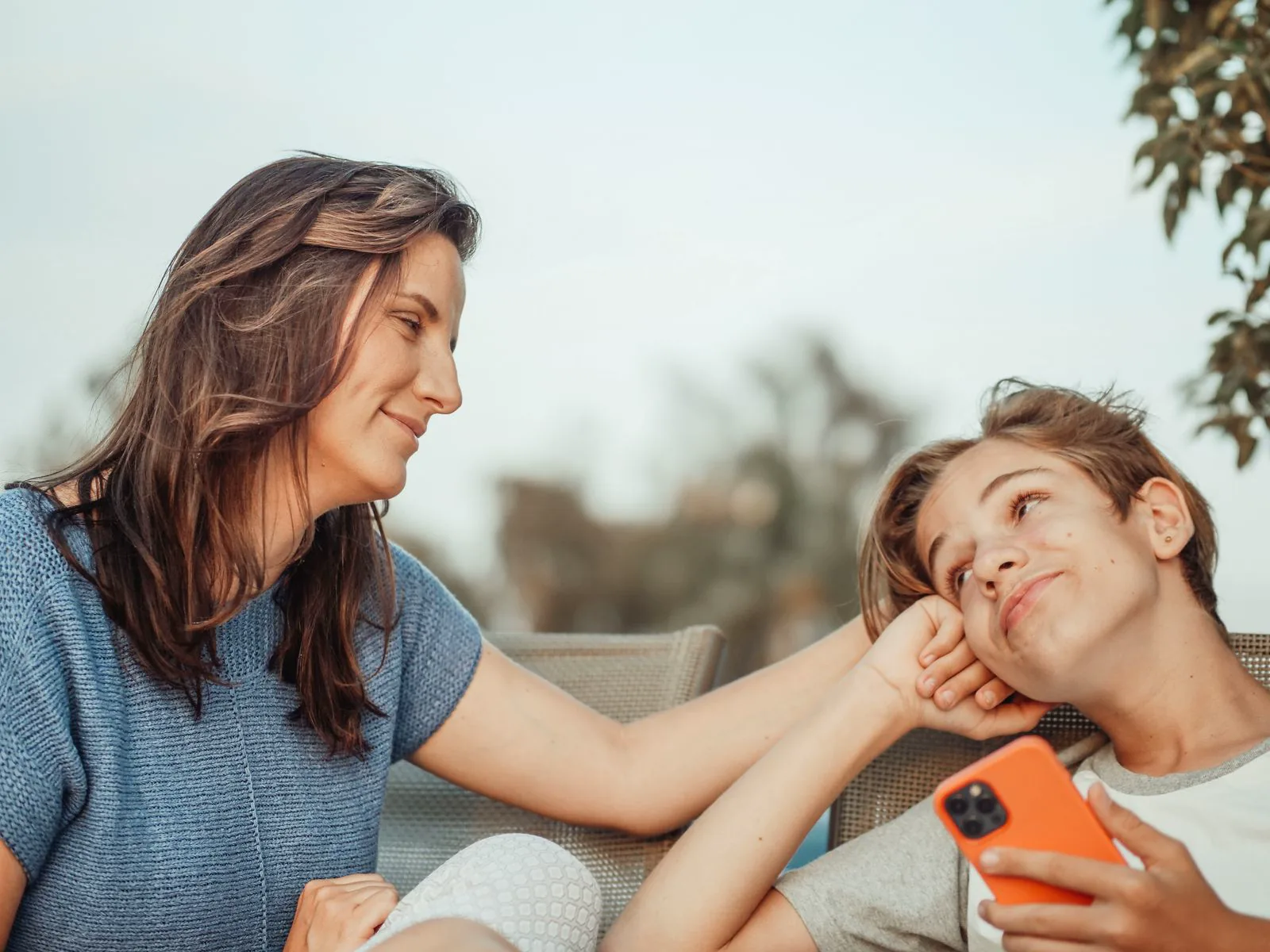 Parent and teenager talking warmly together outdoors
